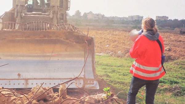 Rachel Corrie with bullhorn, bulldozer