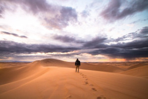 man walking alone in desert
