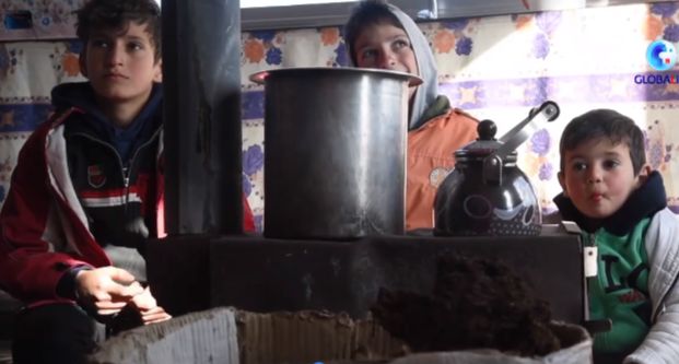 Syrian children behind stove