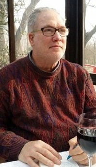 Jeff sitting, writing, looking away - cropped
